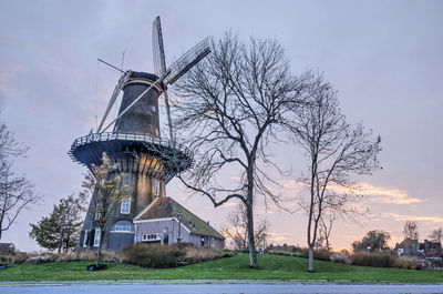 Traditional windmill on field against sky