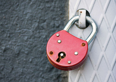 Close-up of red padlock on door