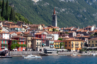 Sailboats in sea with buildings in background