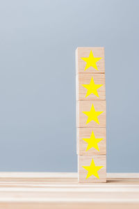 Close-up of information sign on table against blue background