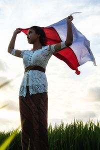 Woman with umbrella standing on field