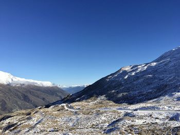 Scenic view of snowcapped mountains against clear blue sky