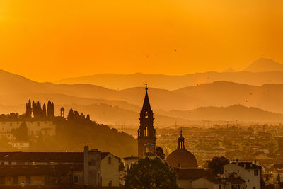 Buildings against sky during sunset in city