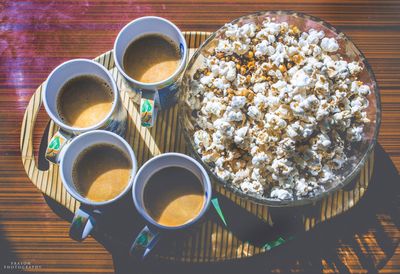 High angle view of coffee cups with popcorns on table