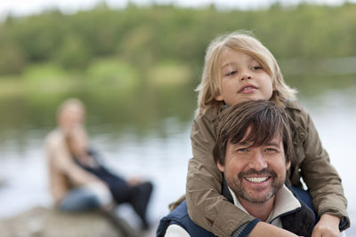 Portrait of father carrying son on shoulders