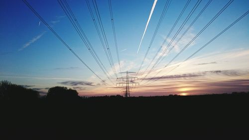 Silhouette of electricity pylon against sky during sunset