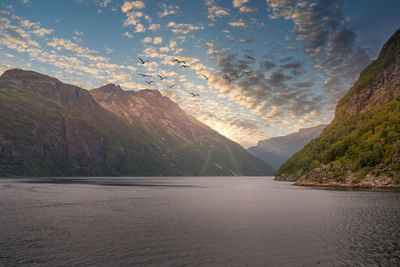 Scenic view of sea and mountains against sky