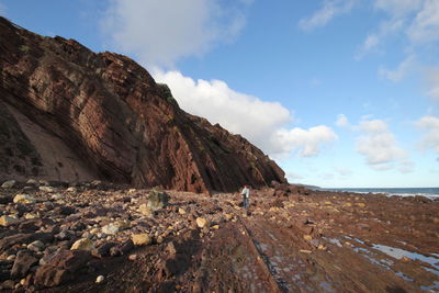 Low angle view of rock formations against cloudy sky