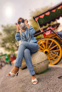 Portrait of young woman sitting on street