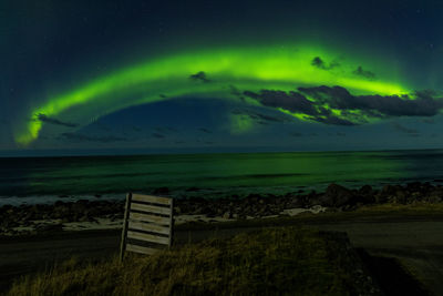 Scenic view of green landscape against sky at night