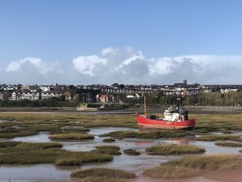 Boat moored on sea against sky