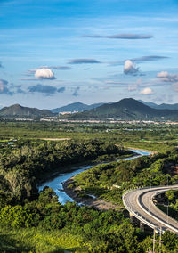 High angle view of s-shape road and river against clear blue sky