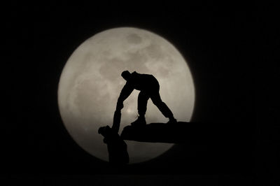 Silhouette man against moon at night