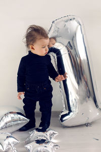 Baby boy in black clothes one year with silver inflatable figure