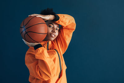 Low angle view of basketball against blue background