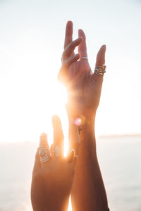 Cropped hand of woman against sky