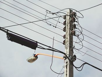 Low angle view of electricity pylon against sky