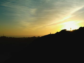 Scenic view of silhouette mountains against sky at sunset