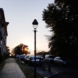 Street in city against sky at sunset