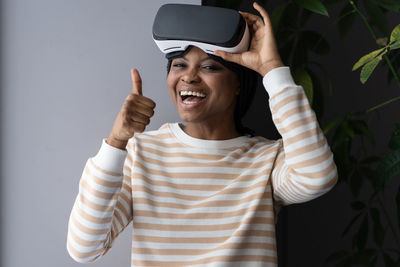 Afro woman in vr goggles headset hold thumb up happy playing video games wear simulator glasses