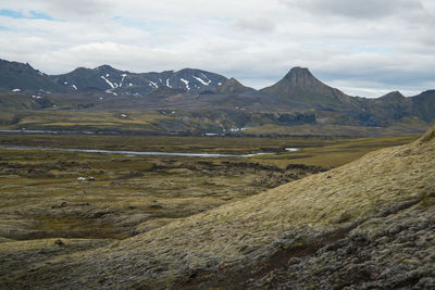 Scenic view of mountains against cloudy sky