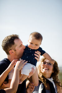 Dad holds & kisses son as family looks on