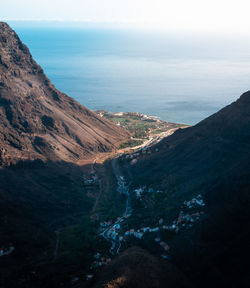 High angle view of sea and mountains against sky