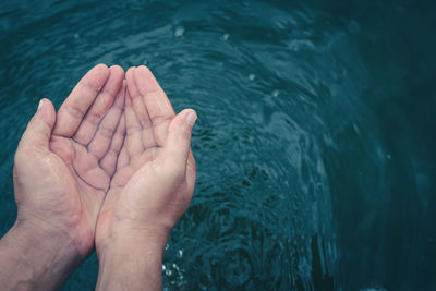 High angle view of person hand in sea
