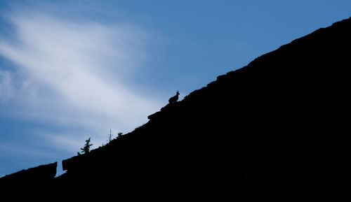 Low angle view of silhouette rocks against sky