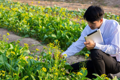 Young man looking away while sitting on mobile phone