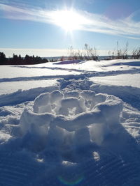Scenic view of snow covered field against sky