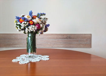 Close-up of vase on table against wall