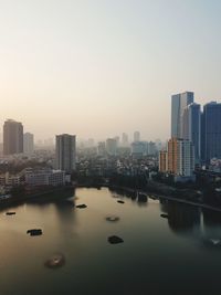 River amidst buildings in city against clear sky