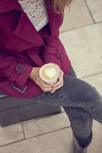 High angle view of woman holding coffee cup