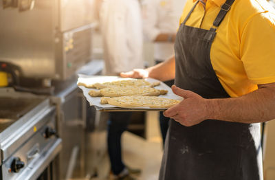 Midsection of man preparing food in kitchen