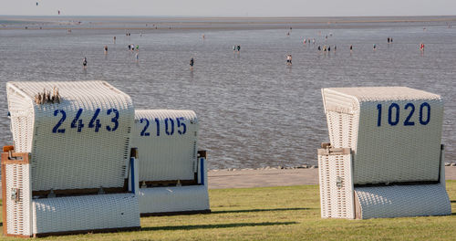 Hooded chairs on beach against sky