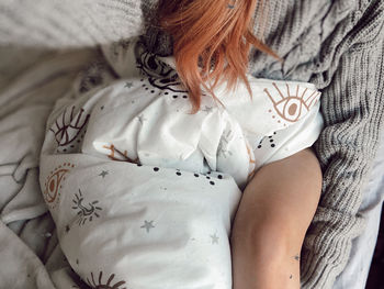 High angle view of woman relaxing on bed at home