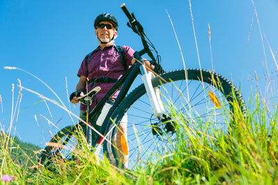 Low angle view of man riding bicycle on field