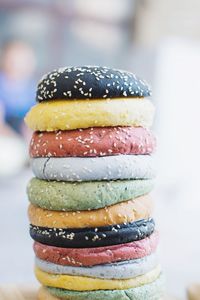 Stack of colorful buns with sesame seeds on table