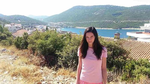 Young woman standing by plants against mountain