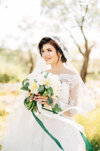 Portrait of woman with pink flowers against blurred background