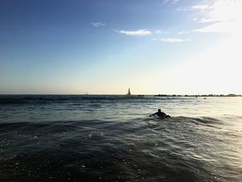 Silhouette man in sea against clear sky