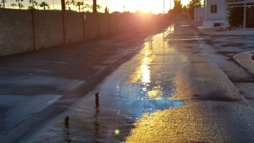 Reflection of sun in puddle on street