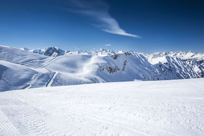 Scenic view of snow mountains against blue sky