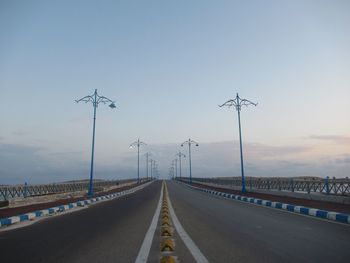 Road by bridge against sky in city