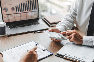 Midsection of businessman working on table