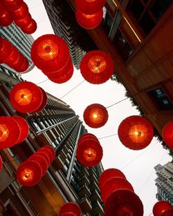 Directly below shot of illuminated lanterns hanging by buildings