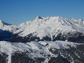 Scenic view of snowcapped mountains against clear blue sky