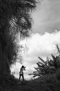 Man standing on field against sky