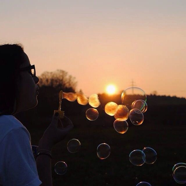 sky, leisure activity, lifestyles, sunset, holding, part of, person, unrecognizable person, focus on foreground, men, clear sky, transportation, cropped, close-up, sun, copy space, lens flare, sunglasses